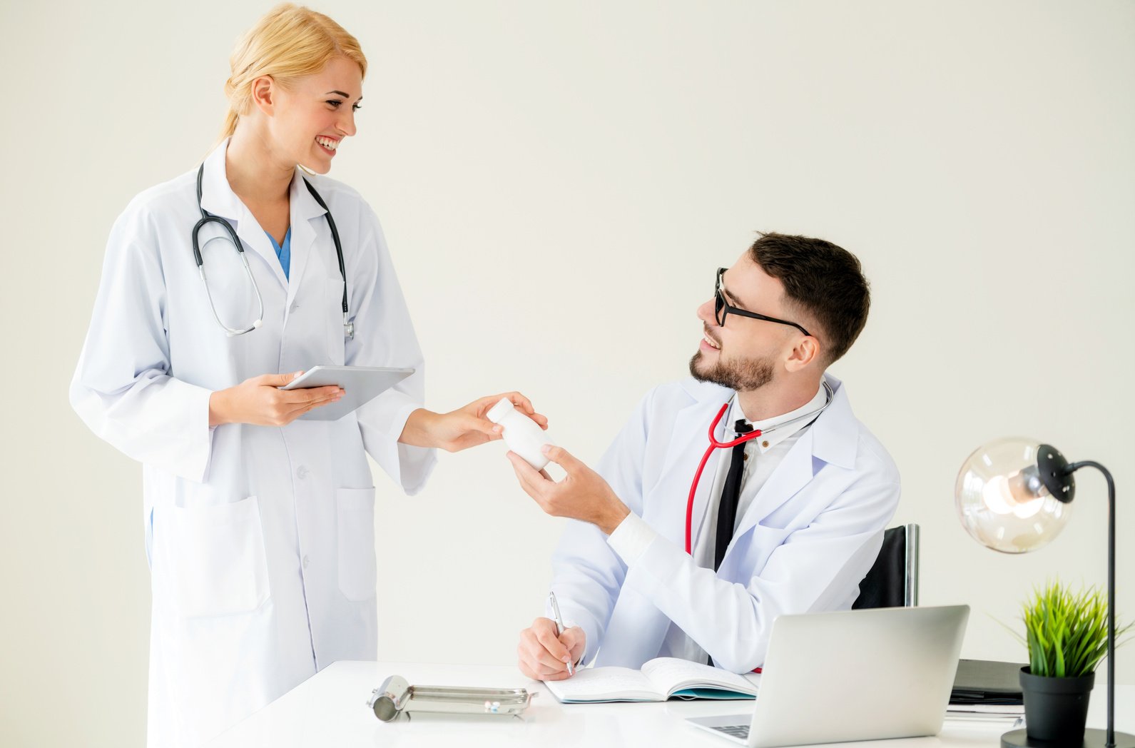 Doctor at hospital passes medicine to partner.